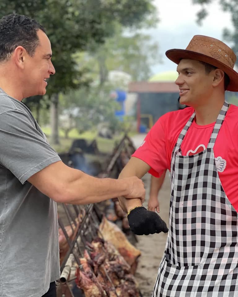 Da Vitória cumprimentando trabalhador em festa comunitária